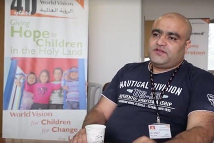 Picture of Mohammed El Halabi with World Vision baner behind him