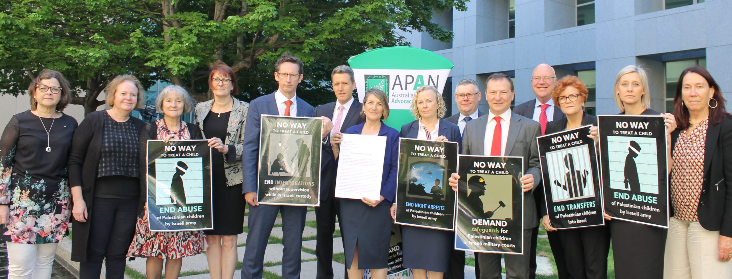 Photo of 15 ALP parliamentarians holding signs "no way to treat a child