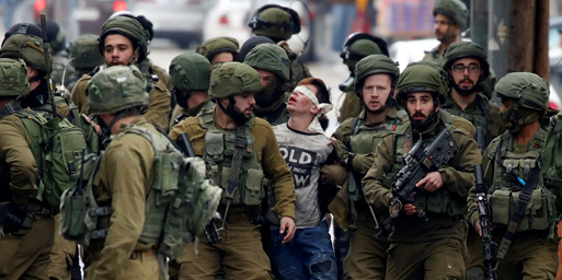 photo of Palestinian child being held and marched along by Israeli soldiers.  The chidl is blindfolded.