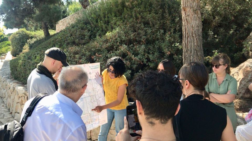 Palestinian woman witha map of Jerusalem and others looking on