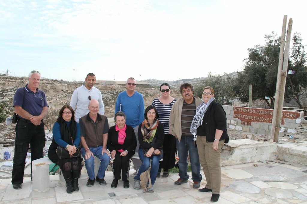 Group of people in front of a demolished house