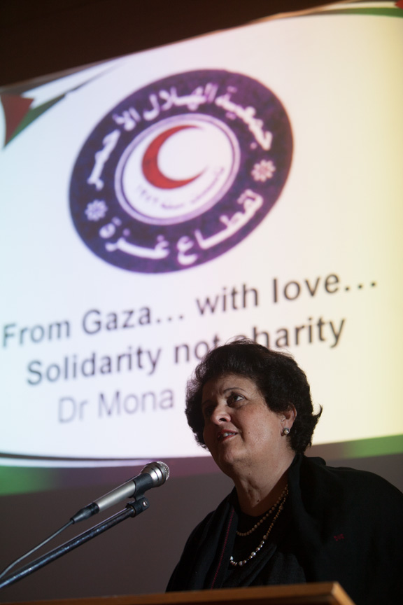 Dr Mona El Farra speaking with slide in the background "From Gaza with love and solidarity in unity"