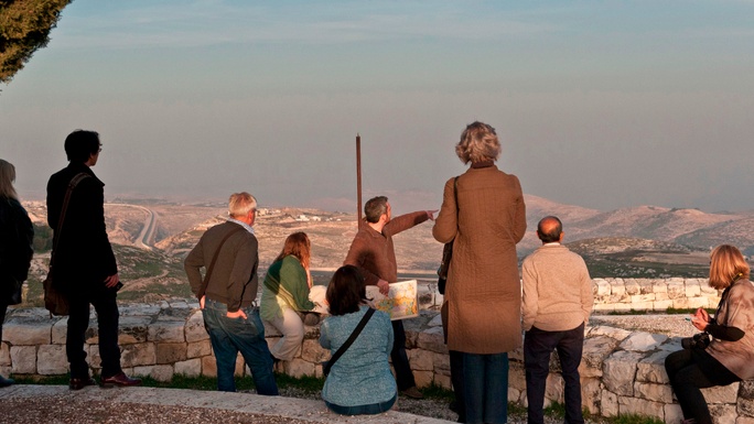 Tour leader looking over Jerusalem with group behind