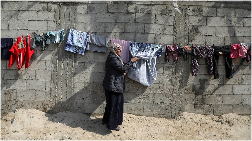 Photo of a Palestinian woman in Gaza city hanging laundry