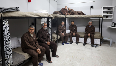Photo of men sitting in prison cell