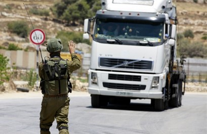 Israeli soldier stopping a Palestinian truck