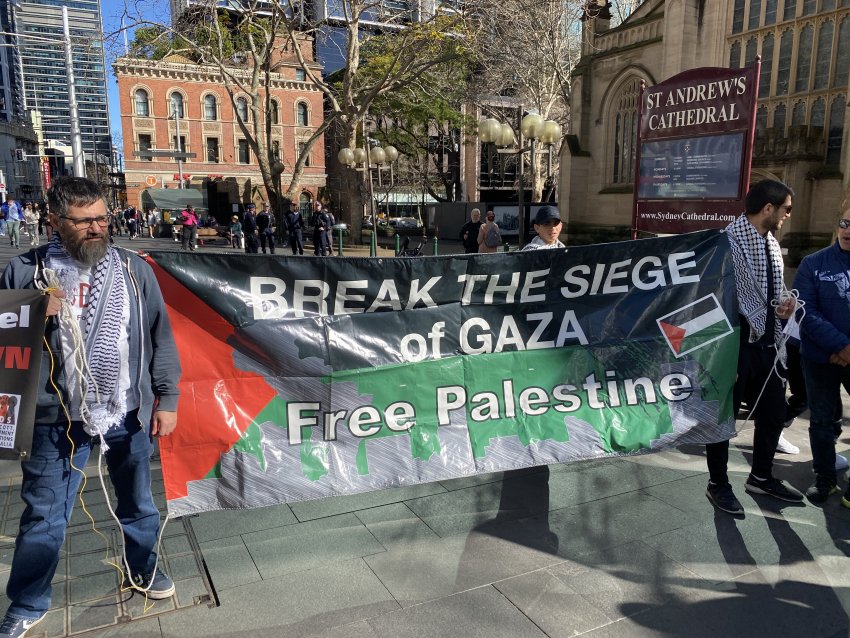 Image of pro-Palestinian protesters in Sydney holding a banner with the words 'break the siege of Gaza' and 'Free Palestine'