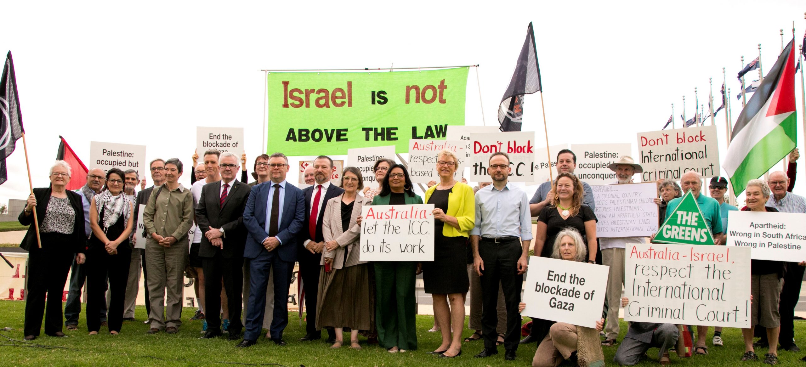 Group outside parliament house with signs "Israel is not above the law"