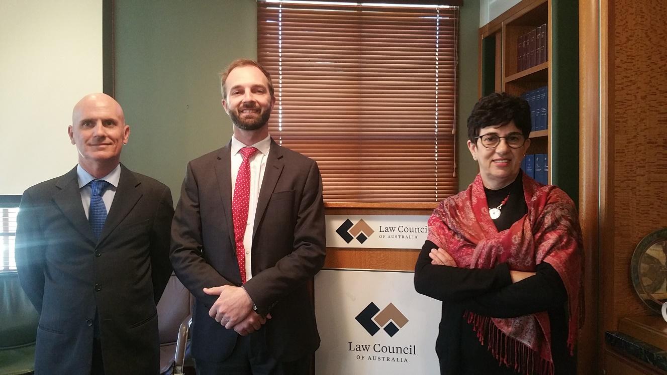 Three people standing at a podium with words "Law Council" on it