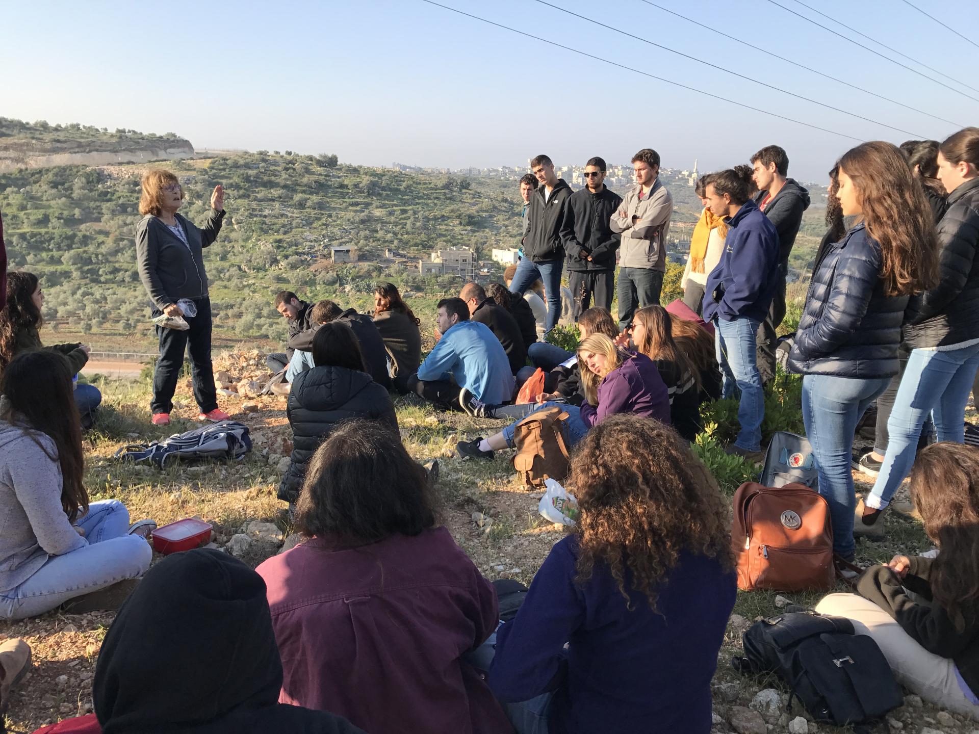 A woman standing in front of a group of people in the West Bank