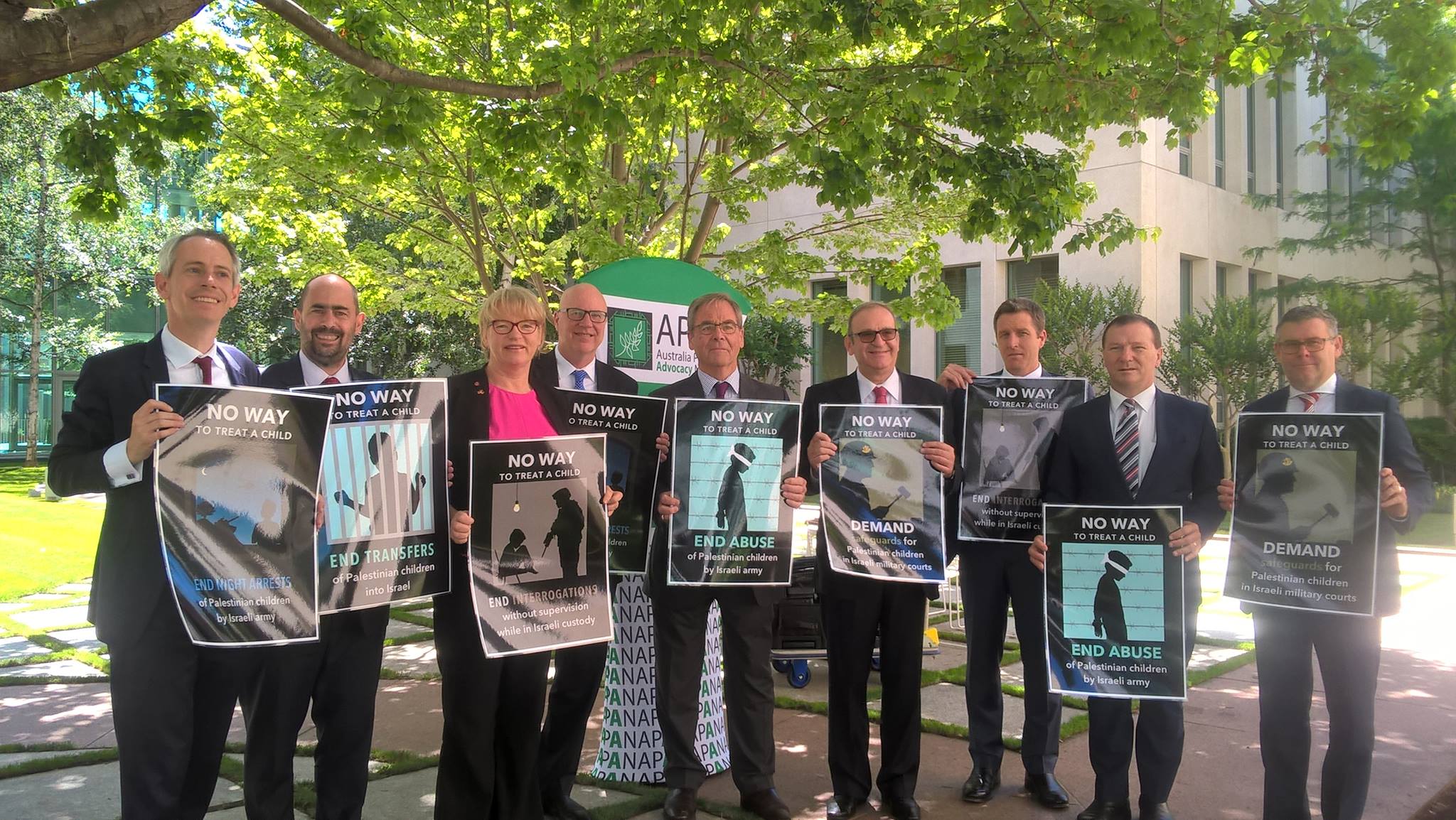 Politicians holding posters protesting the treatment of Palestinian children by the Israeli military
