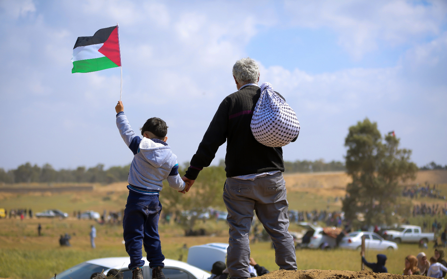 Young child with Palestinian flag and man with Kuffiyeh Bukjeh